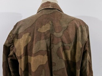Windbluse für Gebirgstruppen der Wehrmacht aus italienischem Tarnmaterial. Offizielle Produktion mit Reichsbetriebsnummer und Grössenstempel. Getragenes Stück, selten