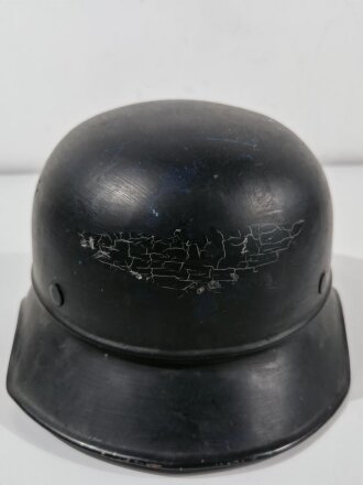 Luftschutz Stahlhelm. Eingestaubt, überlackiert, darunter das Abzeichen