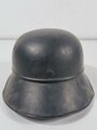 Luftschutz Stahlhelm. Eingestaubt, überlackiert, darunter das Abzeichen