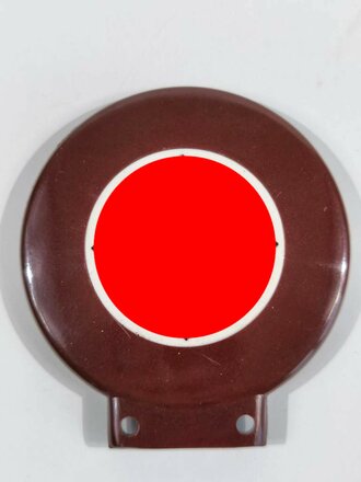 Fahrrademblem schwarzlackiertes Hakenkreuz auf weiß in rotbraunem Preßstoffrahmen. Ungebrauchtes Stück, bei einem der HK ca. 15% Farbverlust. Höhe insgesamt 80mm