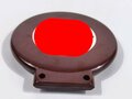 Fahrrademblem schwarzlackiertes Hakenkreuz auf weiß in rotbraunem Preßstoffrahmen. Ungebrauchtes Stück, bei einem der HK ca. 15% Farbverlust. Höhe insgesamt 80mm