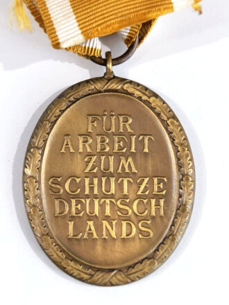 Deutsches Schutzwall- Ehrenzeichen in Buntmetall mit langem Bandabschnitt