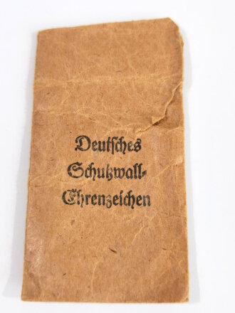 Deutsches Schutzwall- Ehrenzeichen in Buntmetall mit Verleihungstüte, diese mit Hersteller " Peter Wilhelm Heb, Lüdenscheid i. W. " Tüte oben seitlich eingerissen