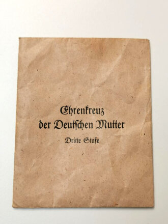 Ehrenkreuz der Deutschen Mutter dritte Stufe mit Verleihungstüte, diese mit Hersteller Louis Gottlieb & Söhne gestempelt, dazu  die zugehörige Verleihungsurkunde für eine Frau aus Lohrheim