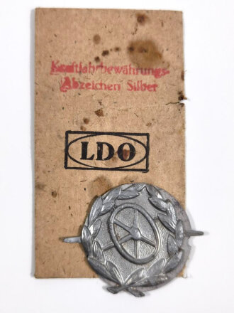 Kraftfahrbewährungsabzeichen in Silber mit Verleihungstüte, Abzeichen mit Gegenplatte diese Lose, Verleihungstüte seitlich eingerissen und Fleckig, seltenes zusammengehöriges Set