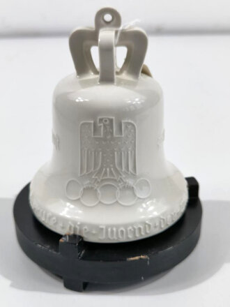 Olympische Spiele 1936 Berlin, Olympia Glocke aus Porzellan der Firma KPM, auf zugehörigem Holzsockel. Unbeschädigt, Gesamthöhe etwa 15cm