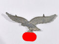 Luftwaffe, Adler für eine Schirmmütze, ungetragenes Stück aus altem Bestand, Eisenblech versilbert. Späte Fertigung mit mitgeprägten Splinten, sie erhalten ein ( 1) Stück