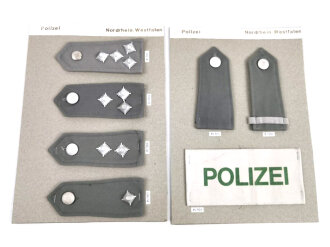 Konvolut von Schulterstücken der Polizei Nordrhein- Westfalen und eine Armbinde der Polizei, alles auf einen Karton getackert