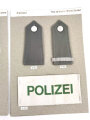 Konvolut von Schulterstücken der Polizei Nordrhein- Westfalen und eine Armbinde der Polizei, alles auf einen Karton getackert