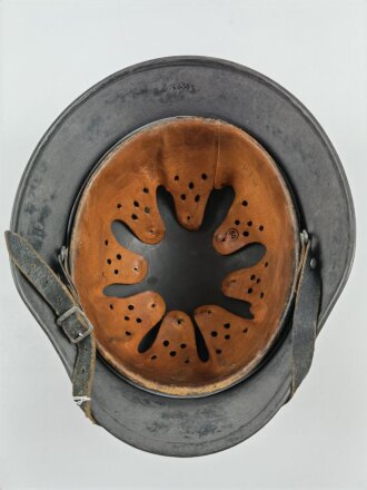 Stahlhelm Modell 1940 der Wehrmacht. Originales Innenfutter, Nieten und Glocke Q66. Neuzeitlich lackiert und mit Emblemen der Polizei versehen, der Kinnriemen ist ebenfalls eine Reproduktion.