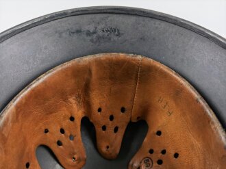 Stahlhelm Modell 1940 der Wehrmacht. Originales Innenfutter, Nieten und Glocke Q66. Neuzeitlich lackiert und mit Emblemen der Polizei versehen, der Kinnriemen ist ebenfalls eine Reproduktion.