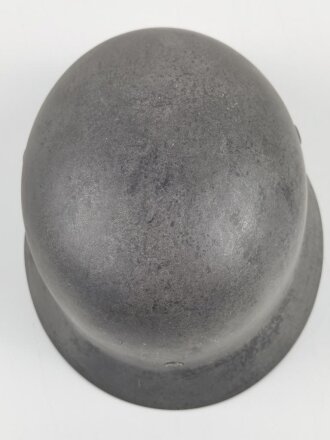 Stahlhelm Modell 1940 der Wehrmacht. Originales Innenfutter, Nieten und Glocke Q66. Neuzeitlich lackiert und mit Emblemen der Polizei versehen, der Kinnriemen ist ebenfalls eine Reproduktion.