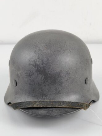 Stahlhelm Modell 1940 der Wehrmacht. Originales Innenfutter, Nieten und Glocke Q66. Neuzeitlich lackiert und mit Emblemen der Polizei versehen, der Kinnriemen ist ebenfalls eine Reproduktion.