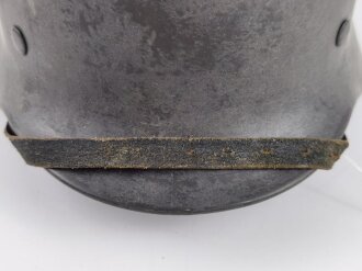Stahlhelm Modell 1940 der Wehrmacht. Originales Innenfutter, Nieten und Glocke Q66. Neuzeitlich lackiert und mit Emblemen der Polizei versehen, der Kinnriemen ist ebenfalls eine Reproduktion.