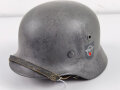 Stahlhelm Modell 1940 der Wehrmacht. Originales Innenfutter, Nieten und Glocke Q66. Neuzeitlich lackiert und mit Emblemen der Polizei versehen, der Kinnriemen ist ebenfalls eine Reproduktion.