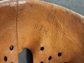 Stahlhelm Modell 1940 der Wehrmacht. Originales Innenfutter, Nieten und Glocke Q66. Neuzeitlich lackiert und mit Emblemen der Polizei versehen, der Kinnriemen ist ebenfalls eine Reproduktion.