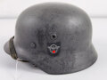 Stahlhelm Modell 1940 der Wehrmacht. Originales Innenfutter, Nieten und Glocke Q66. Neuzeitlich lackiert und mit Emblemen der Polizei versehen, der Kinnriemen ist ebenfalls eine Reproduktion.