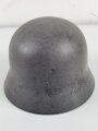 Stahlhelm Modell 1940 der Wehrmacht. Originales Innenfutter, Nieten und Glocke Q66. Neuzeitlich lackiert und mit Emblemen der Polizei versehen, der Kinnriemen ist ebenfalls eine Reproduktion.