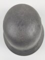 Stahlhelm Modell 1940 der Wehrmacht. Originales Innenfutter, Nieten und Glocke Q66. Neuzeitlich lackiert und mit Emblemen der Polizei versehen, der Kinnriemen ist ebenfalls eine Reproduktion.