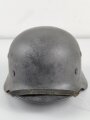 Stahlhelm Modell 1940 der Wehrmacht. Originales Innenfutter, Nieten und Glocke Q66. Neuzeitlich lackiert und mit Emblemen der Polizei versehen, der Kinnriemen ist ebenfalls eine Reproduktion.