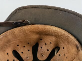 Stahlhelm Modell 1940 der Wehrmacht. Vermutlich in Teilen originales Innenfutter, Nieten und Glocke SE64. Neuzeitlich lackiert und mit Emblemen der Waffen SS versehen, der Kinnriemen ist ebenfalls eine Reproduktion.