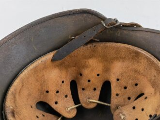 Stahlhelm Modell 1940 der Wehrmacht. Vermutlich in Teilen originales Innenfutter, Nieten und Glocke SE64. Neuzeitlich lackiert und mit Emblemen der Waffen SS versehen, der Kinnriemen ist ebenfalls eine Reproduktion.