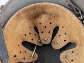 Stahlhelm Modell 1940 der Wehrmacht. Vermutlich in Teilen originales Innenfutter, Nieten und Glocke SE64. Neuzeitlich lackiert und mit Emblemen der Waffen SS versehen, der Kinnriemen ist ebenfalls eine Reproduktion.