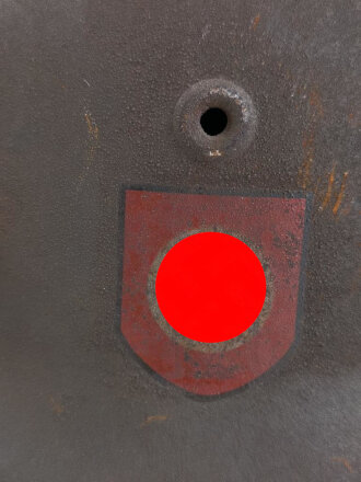 Stahlhelm Modell 1940 der Wehrmacht. Vermutlich in Teilen originales Innenfutter, Nieten und Glocke SE64. Neuzeitlich lackiert und mit Emblemen der Waffen SS versehen, der Kinnriemen ist ebenfalls eine Reproduktion.