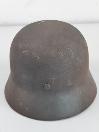 Stahlhelm Modell 1940 der Wehrmacht. Vermutlich in Teilen originales Innenfutter, Nieten und Glocke SE64. Neuzeitlich lackiert und mit Emblemen der Waffen SS versehen, der Kinnriemen ist ebenfalls eine Reproduktion.