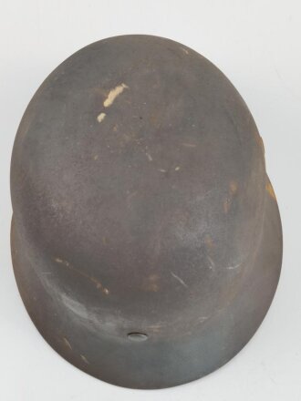 Stahlhelm Modell 1940 der Wehrmacht. Vermutlich in Teilen originales Innenfutter, Nieten und Glocke SE64. Neuzeitlich lackiert und mit Emblemen der Waffen SS versehen, der Kinnriemen ist ebenfalls eine Reproduktion.
