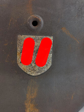 Stahlhelm Modell 1940 der Wehrmacht. Vermutlich in Teilen originales Innenfutter, Nieten und Glocke SE64. Neuzeitlich lackiert und mit Emblemen der Waffen SS versehen, der Kinnriemen ist ebenfalls eine Reproduktion.