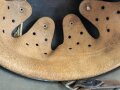 Stahlhelm Modell 1940 der Wehrmacht. Vermutlich in Teilen originales Innenfutter, Nieten und Glocke SE64. Neuzeitlich lackiert und mit Emblemen der Waffen SS versehen, der Kinnriemen ist ebenfalls eine Reproduktion.