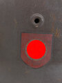 Stahlhelm Modell 1940 der Wehrmacht. Vermutlich in Teilen originales Innenfutter, Nieten und Glocke SE64. Neuzeitlich lackiert und mit Emblemen der Waffen SS versehen, der Kinnriemen ist ebenfalls eine Reproduktion.