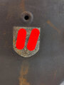 Stahlhelm Modell 1940 der Wehrmacht. Vermutlich in Teilen originales Innenfutter, Nieten und Glocke SE64. Neuzeitlich lackiert und mit Emblemen der Waffen SS versehen, der Kinnriemen ist ebenfalls eine Reproduktion.