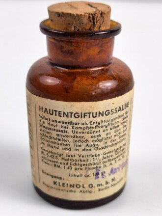 Glasflasche "Hautentgiftungssalbe" datiert 1943. Gesamthöhe 9,5cm.