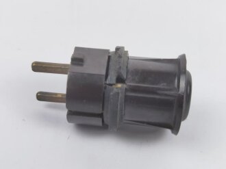 Stecker aus dunkelbrauner Preßmasse, datiert 1935