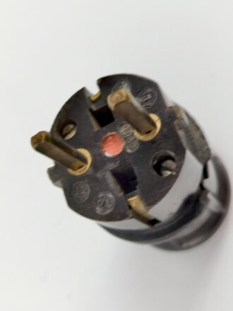 Stecker aus dunkelbrauner Preßmasse, datiert 1935