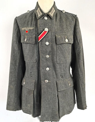 Heer, Feldbluse für Mannschaften Modell 1943. Kammerstück aus italienischem Tuch . Die Kragenspiegel höchstwahrscheinlich original vernäht, der Brustadler ergänzt. Stark getragenes Stück mit diversen älteren Reparaturstellen.