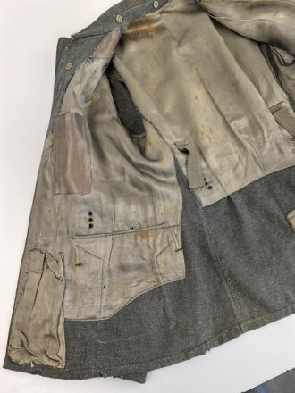 Heer, Feldbluse für Mannschaften Modell 1943. Kammerstück aus italienischem Tuch . Die Kragenspiegel höchstwahrscheinlich original vernäht, der Brustadler ergänzt. Stark getragenes Stück mit diversen älteren Reparaturstellen.
