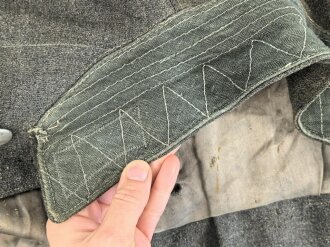 Heer, Feldbluse für Mannschaften Modell 1943. Kammerstück aus italienischem Tuch . Die Kragenspiegel höchstwahrscheinlich original vernäht, der Brustadler ergänzt. Stark getragenes Stück mit diversen älteren Reparaturstellen.