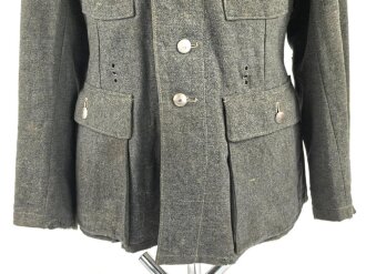 Heer, Feldbluse für Mannschaften Modell 1943. Kammerstück aus italienischem Tuch . Die Kragenspiegel höchstwahrscheinlich original vernäht, der Brustadler ergänzt. Stark getragenes Stück mit diversen älteren Reparaturstellen.