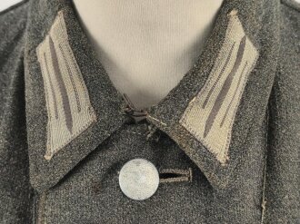 Heer, Feldbluse für Mannschaften Modell 1943. Kammerstück aus italienischem Tuch . Die Kragenspiegel höchstwahrscheinlich original vernäht, der Brustadler ergänzt. Stark getragenes Stück mit diversen älteren Reparaturstellen.