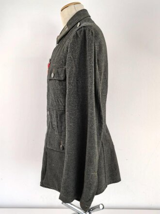 Heer, Feldbluse für Mannschaften Modell 1943. Kammerstück aus italienischem Tuch . Die Kragenspiegel höchstwahrscheinlich original vernäht, der Brustadler ergänzt. Stark getragenes Stück mit diversen älteren Reparaturstellen.