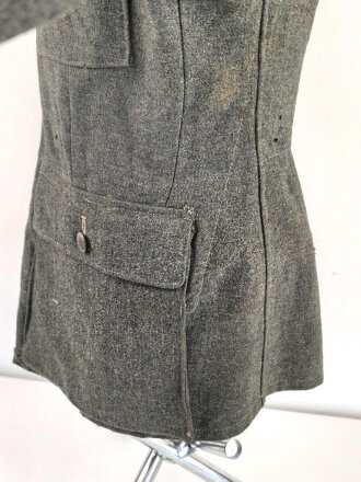 Heer, Feldbluse für Mannschaften Modell 1943. Kammerstück aus italienischem Tuch . Die Kragenspiegel höchstwahrscheinlich original vernäht, der Brustadler ergänzt. Stark getragenes Stück mit diversen älteren Reparaturstellen.