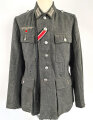 Heer, Feldbluse für Mannschaften Modell 1943. Kammerstück aus italienischem Tuch . Die Kragenspiegel höchstwahrscheinlich original vernäht, der Brustadler ergänzt. Stark getragenes Stück mit diversen älteren Reparaturstellen.