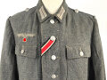 Heer, Feldbluse für Mannschaften Modell 1943. Kammerstück aus italienischem Tuch . Die Kragenspiegel höchstwahrscheinlich original vernäht, der Brustadler ergänzt. Stark getragenes Stück mit diversen älteren Reparaturstellen.
