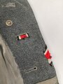 Heer, Feldbluse für Mannschaften Modell 1943. Kammerstück aus italienischem Tuch . Die Kragenspiegel höchstwahrscheinlich original vernäht, der Brustadler ergänzt. Stark getragenes Stück mit diversen älteren Reparaturstellen.