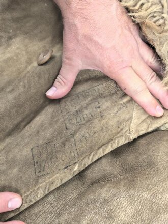 Schwerer Wintermantel mit großen Kastenstempel, dieser erinnert an russische Stempel. Gewaltige Grösse, riecht nach altem Fell und Keller.