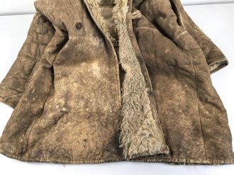Schwerer Wintermantel mit großen Kastenstempel, dieser erinnert an russische Stempel. Gewaltige Grösse, riecht nach altem Fell und Keller.