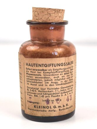 Glasflasche "Hautentgiftungssalbe" datiert 1943. Gesamthöhe 9,5cm